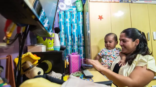 Una mujer con un bebé en casa, donde guarda bolsas de pañales