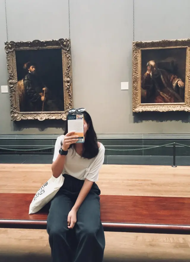 Una chica sostiene un cuaderno.