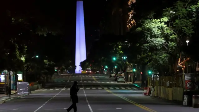 Uma pessoa andando sozinhacashback esportiva betBuenos Aires com o Obelisco ao fundo