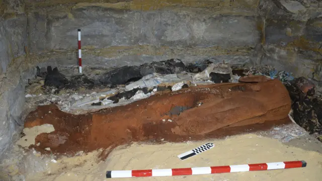 Momia hallada en Saqqara en la que puede apenas verse la máscara de plata