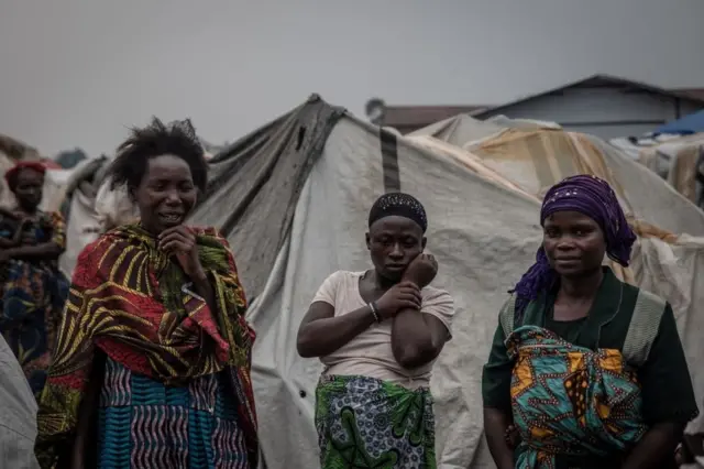 Women discuss the state of the Nyiragongo volcano disaster at the Kayembe camp for displaced people, near Goma on August 30, 2021