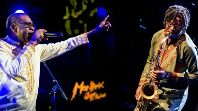 Alain Rodrigue Oyono jouant au saxophone en concert avec Youssou Ndour