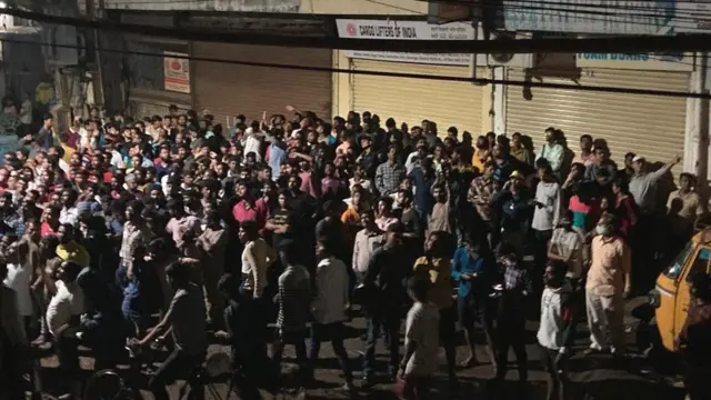 మంటలు చెలరేగిన భవనం ముందు ప్రజలు