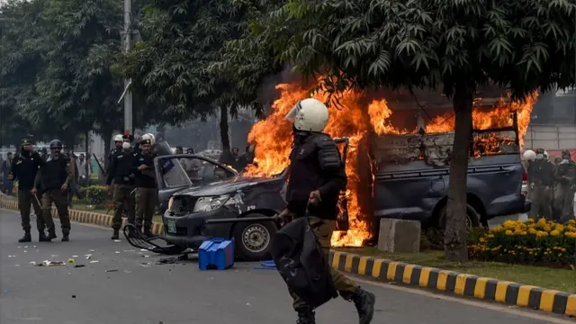 Police gada beside police vehicle wey dey burn afta clash between lawyers and doctors for Lahore on December 11, 2019