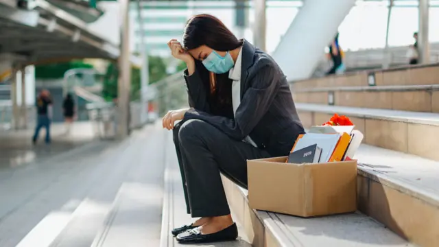 Una mujer usando una mascarilla que fue despedida