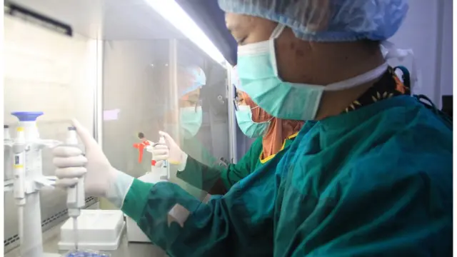 Dokter patologi klinik menunjukkan cara kerja alat Polymerase Chain Reaction (PCR) di Ruang Ektraksi DNA dan RNA Laboratorium Mikrobiologi RSUD Sidoarjo, Jawa Timur, Sabtu (20/06).,