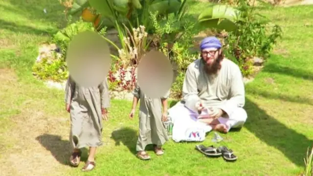 John Georgelas seen with two of his children in a garden