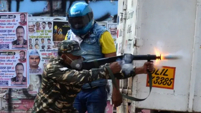 दिल्ली पुलिस आंसू गैस के गोले छोड़ते हुए