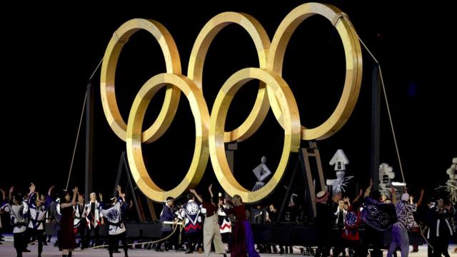 Performers dance in front of a giant golden Olympic Rings during the Opening Ceremony of the Tokyo 2020 Olympic Games at Olympic Stadium on July 23, 2021 in Tokyo, Japan.