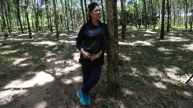 นางม้วนยืนพิงต้นยางในสวน