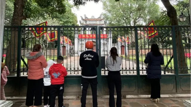Văn Miếu Quốc Tử Giám, nơi thờ nhà hiền triết Khổng Tử, là địa điểm tập trung đông người đi lễ vào bậc nhất Hà Nội mỗi dịp Tết hàng năm, chủ yếu là học sinh và sinh viên. Năm nay, do dịch bệnh, đền ra thông báo đóng cửa nên các sĩ tử đành đứng ngoài cầu khấn.