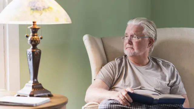 Hombre distraído con libro en la mano