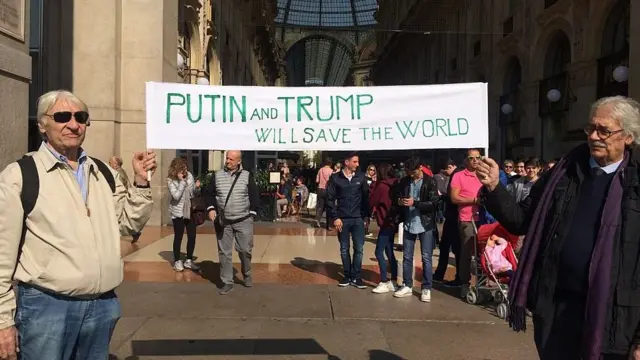Мужчины с плакатом "Путин и Трамп спасут мир"