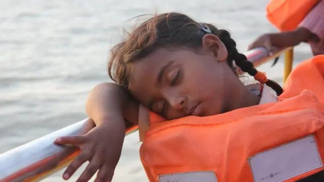 స్కూలుకు వెళ్లేందుకు పుటికాట్ సరస్సులో పడవపై ప్రయాణిస్తున్న విద్యార్థిని