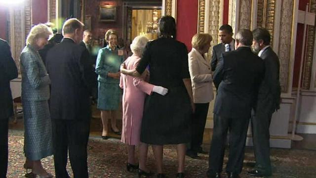 the queen places her arm around Michelle Obama in 2009