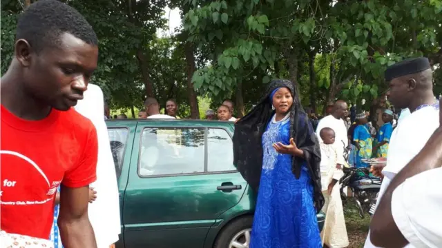 Woman beside a green car