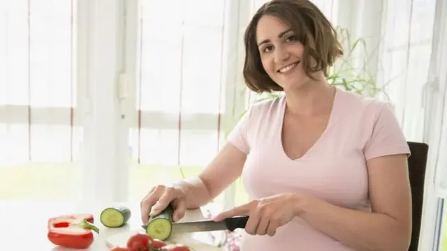 Une femme enceinte en train de préparer un déjeuner sain