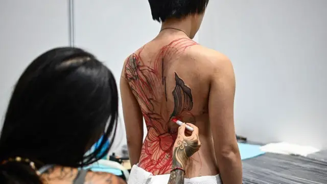 టాటూ వేయించుకున్న మహిళ