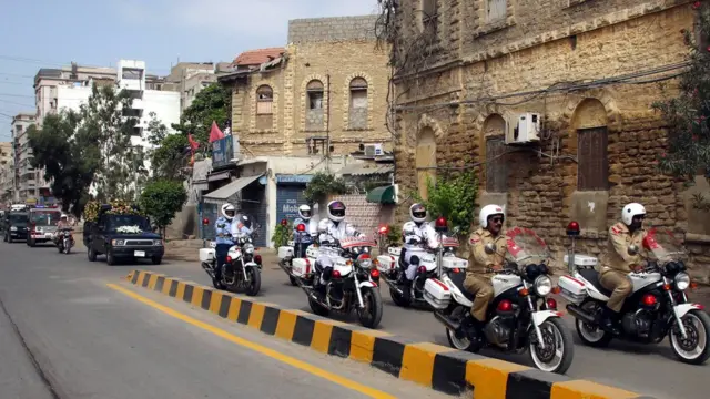 Pakistani military soldiers on motorbikes transport the coffin through Karachi, Pakistan