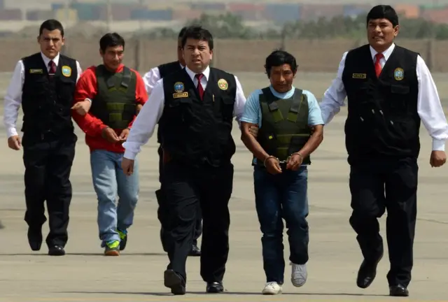 Alexander Alarcon, alias el "Camarada Renán" (izquierda), y Dionisio Ramos, alias "Camarada Yuri", miembros de la guerrilla maoista Sendero Luminoso, escoltados por la policía a su llegada a Lima tras ser detenidos en la región amazónica de Junín el 10 de agosto de 2015.