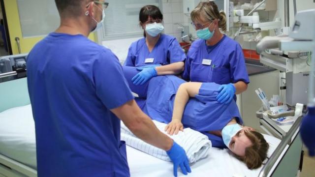 Lo que parece un procedimiento simple requiere de profesionales experimentados. En la foto, un equipo de salud alemán practica cómo se debe cambiar de posición a los pacientes.
