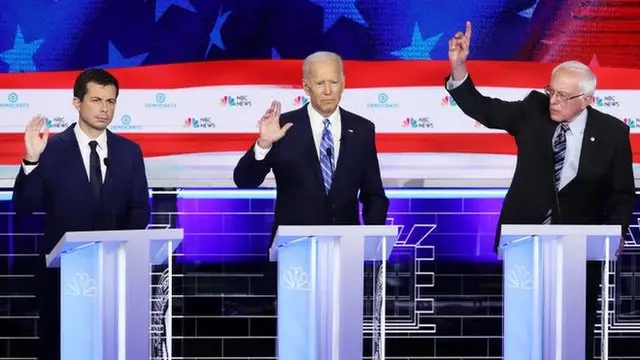 Buttigieg (à esq.), Joe Biden (Centro) e Bernie Sanders (à dir.)