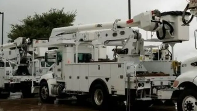 Power company trucks dey on standby in case light go of