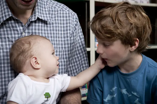 Un bebé acaricia la cara de un niño durante el programa.