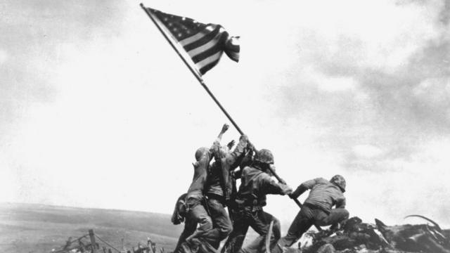 在第二次世界大战最惨烈的一场战斗中，美国士兵举起星条旗。