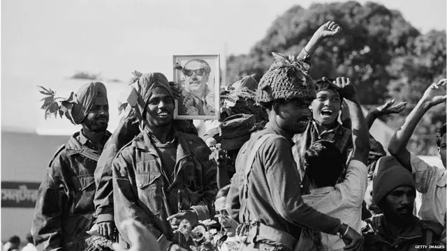 ముక్తి బాహిణి నాయకుడు ముజీబుర్ రెహ్మాన్ ఫోటోతో భారత సైన్యానికి స్వాగతం పలుకుతున్న ముక్తి బాహిణి సైనికులు