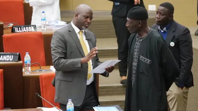 The Gambia Justice Minister Abubacarr Tambadou discusses the bill with a member of Parliament at the national assembly in Banjul, Gambia December 2, 2019.