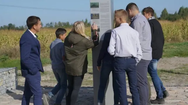 Діти читають текст на інформаційній стелі про Голокост у Барашах