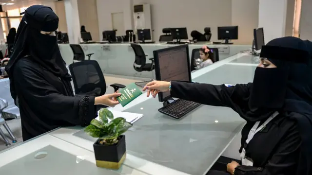 سيدة سعودية تمسك جواز سفرها