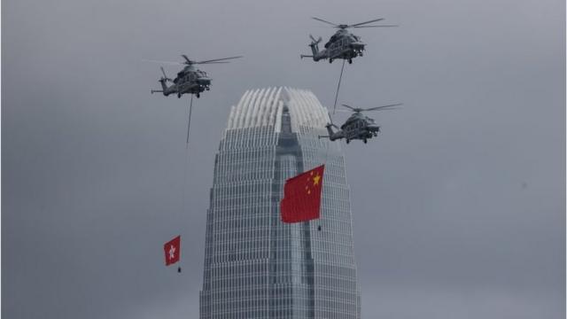 7月1日，香港政府飛行服務隊的直升機在香港會議中心上空展示中國國旗和香港區旗。