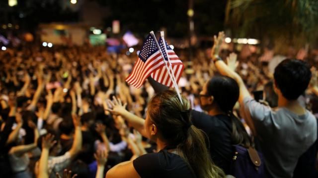 支持法案的示威者举行集会，期间多人挥舞美国国旗。