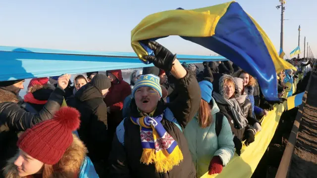 Люди з прапором на мосту
