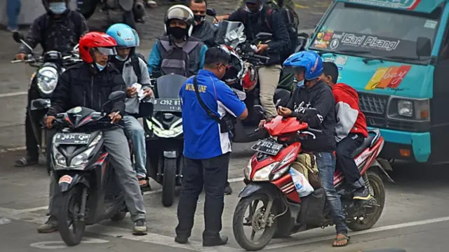 Petugas memeriksa tiket pengguna sepeda motor yang akan menyeberang ke Pulau Sumatera di Pelabuhan Merak, Banten, Sabtu (10/04)