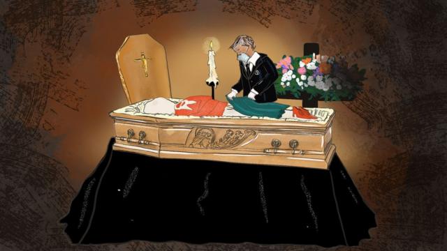 Un trabajadore de una empresa funeraria poniéndole ropa a un cadáver.