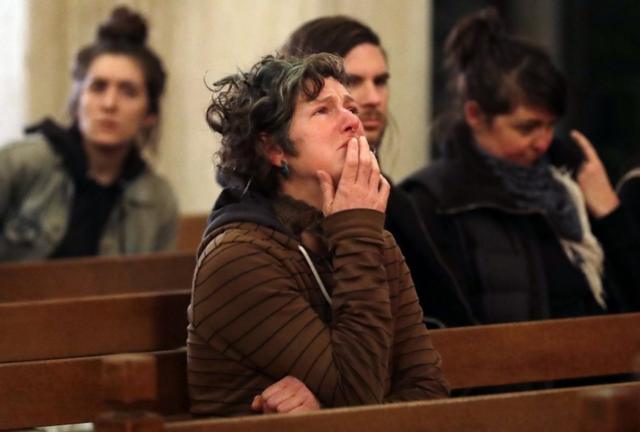 Una mujer llamada Genevieve Griseau con lágrimas en los ojos durante la ceremonia en una capilla de Oakland para recordar a las víctimas del incendio.