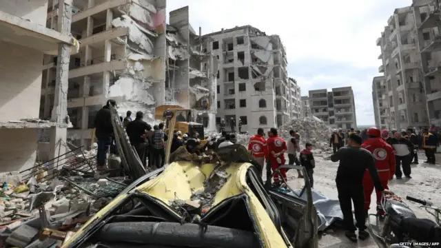 yrian rescue teams and onlookers gather in the morning of April 10, 2018 at the site of an explosion of unknown origin which wrecked a multi-storey building the previous night in the war-battered country's northwestern city of Idlib.