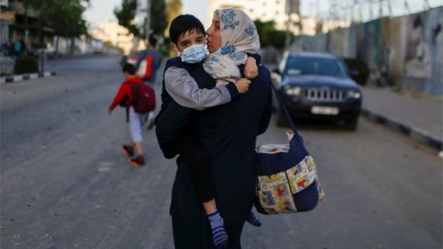 Палестинцы покидают один из домов в Газе