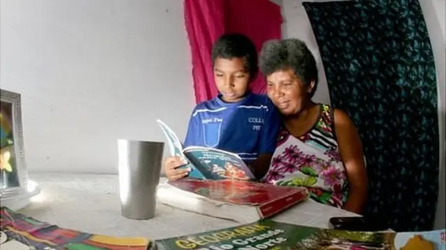 Sandra y Damiao leen un libro juntos.