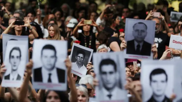 Pessoas seguram fotosslot aviadorvítimas da ditadura militarslot aviadorprotesto contra a comemoração dos 55 do golpe militar,slot aviadorSP