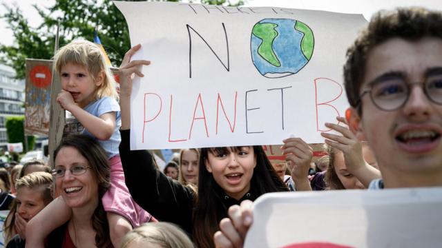 Padres y niños con una pancarta que reza: "no hay planeta B"