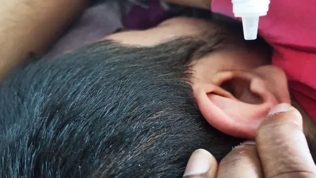 કાનમાં ઇયર ડ્રોપ્સ નાખી રહ્યા છે