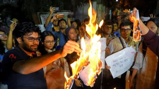 নাগরিকত্ব আইনের কপি জ্বালিয়ে দিচ্ছেন যাদবপুর বিশ্ববিদ্যালয়ের শিক্ষার্থীরা।