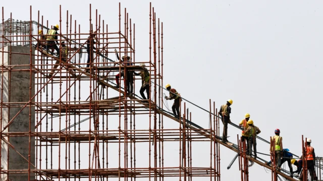 Construction workers stand on scaffolding in Abuja, Nigeria - Thursday 12 March 2020