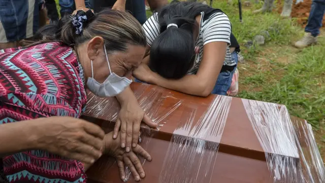 Dos mujeres recostadas contra un cajón