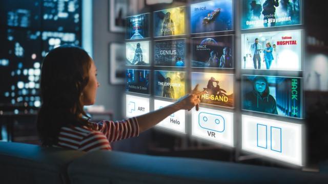 Una mujer selecciona programas en una pantalla virtual de TV