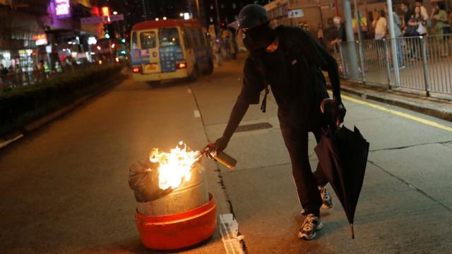 A demonstrator sets a bin on fire in Hong Kong